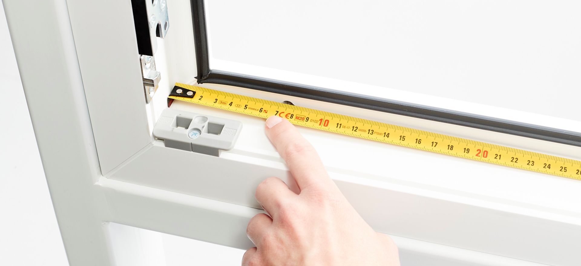 ein Maßband liegt am Fensterrahmen