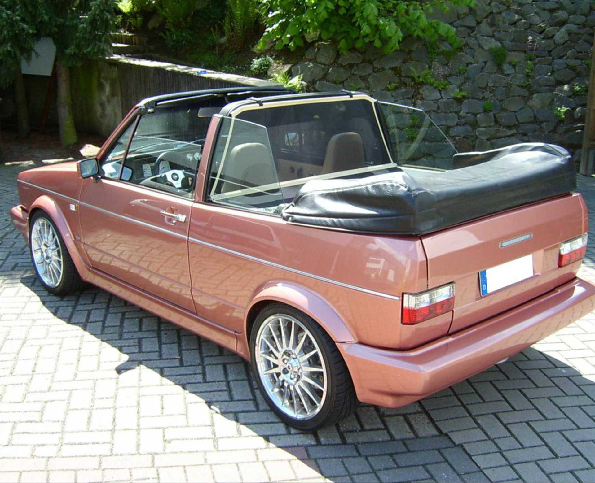 ein rotes Golf 1 Cabrio mit einem BODI Windschott