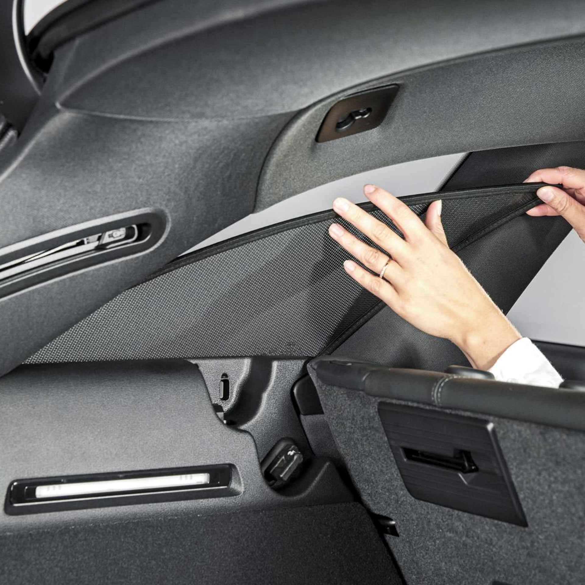 eine Frau bringt den Sonniboy an die hintere Türfenster an