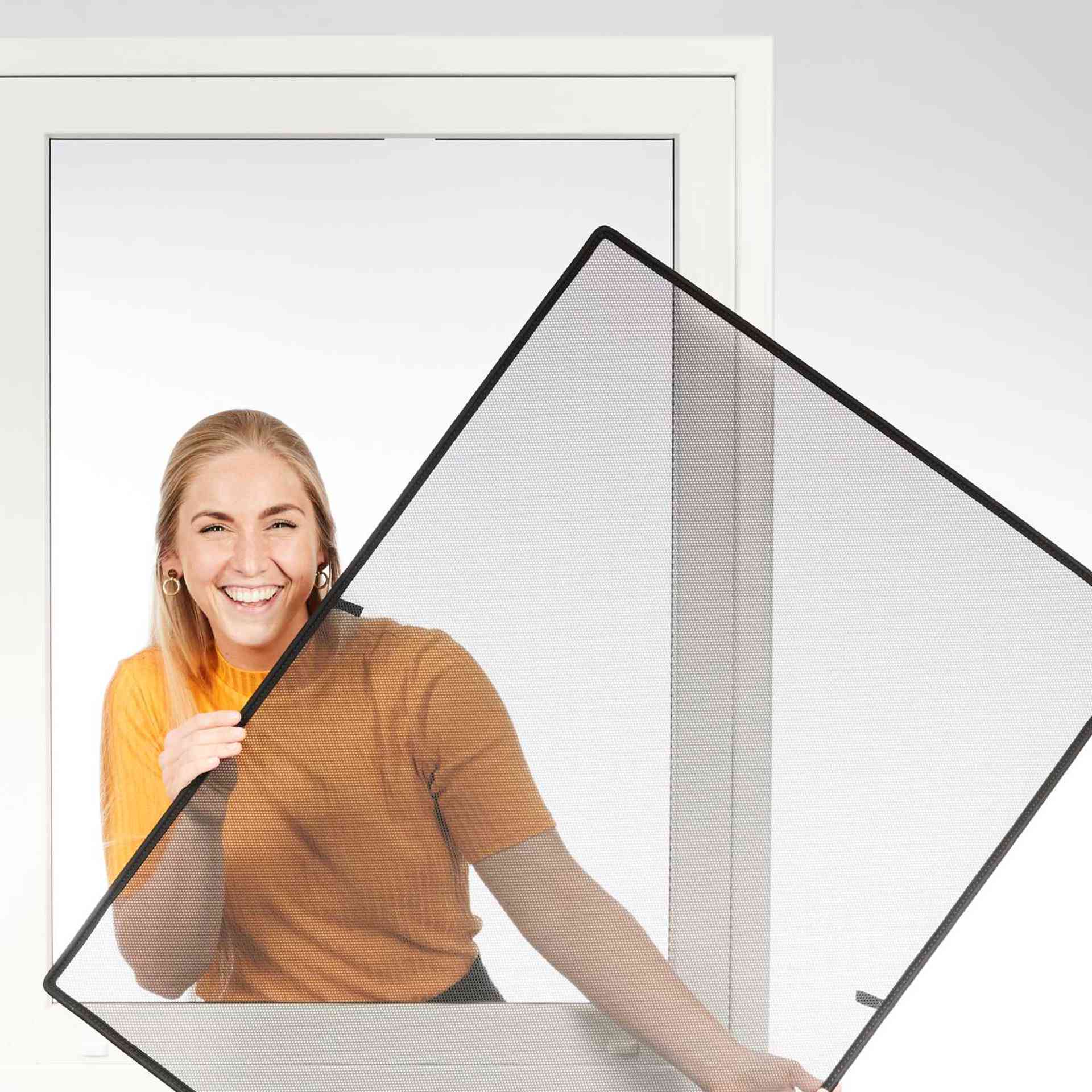 a woman smilingly holds the WinClip through a window