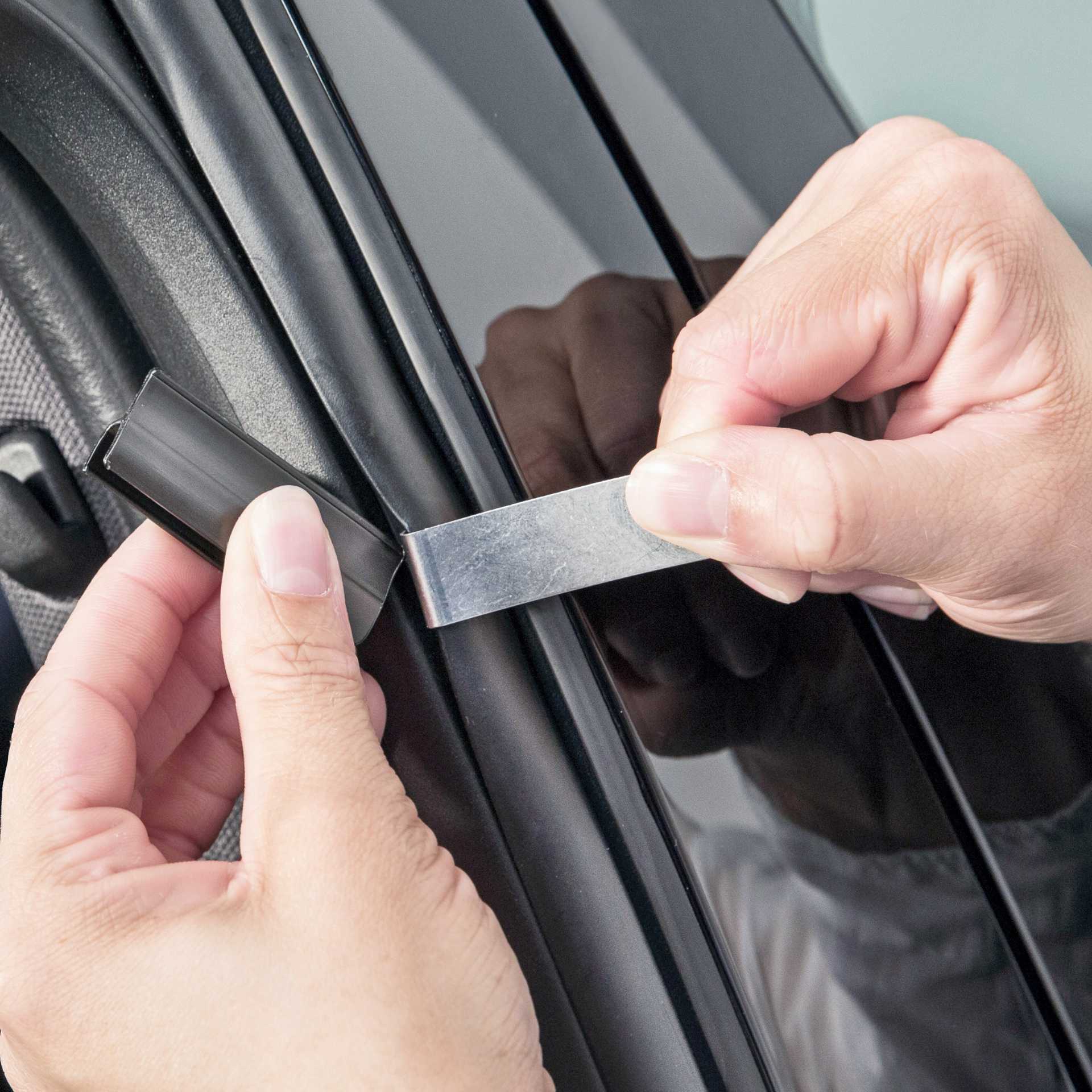 someone attaches a holder to the car windscreen with a tool to install the sunclip